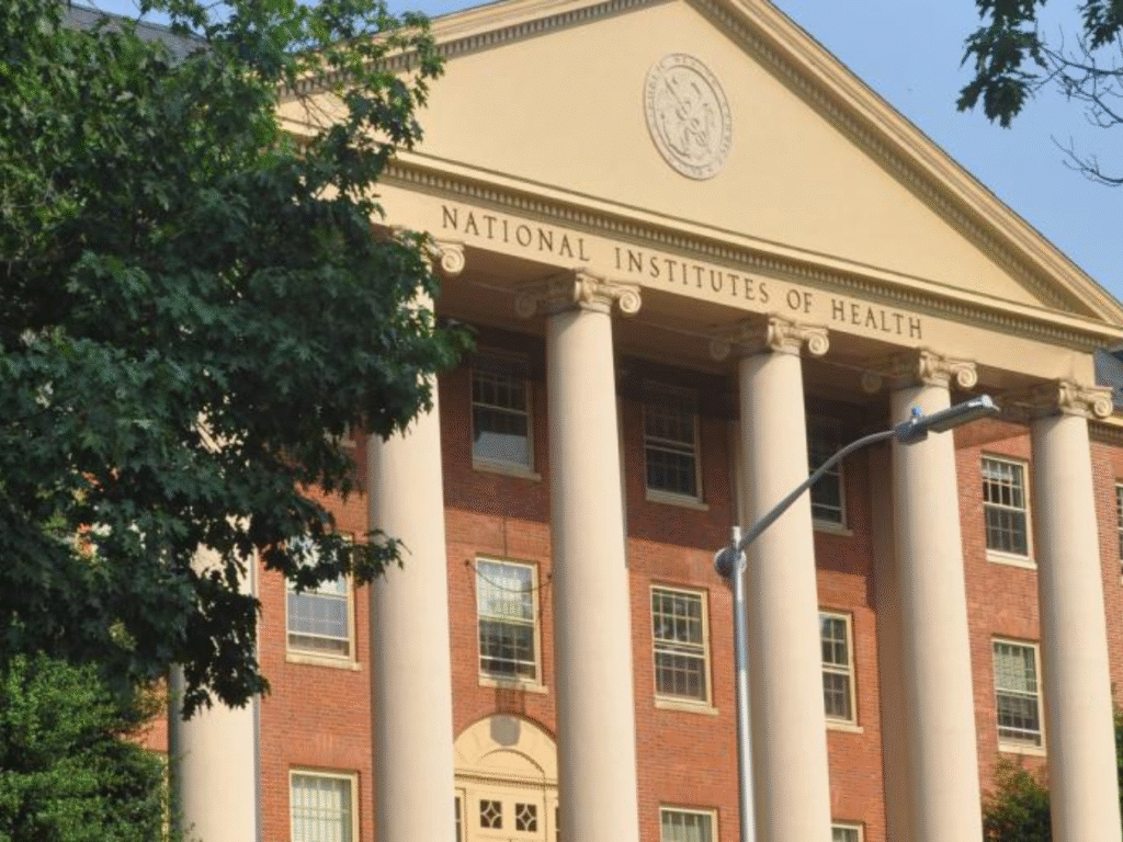 Front view of the National Institutes of Health headquarters building with columns and signage visible.