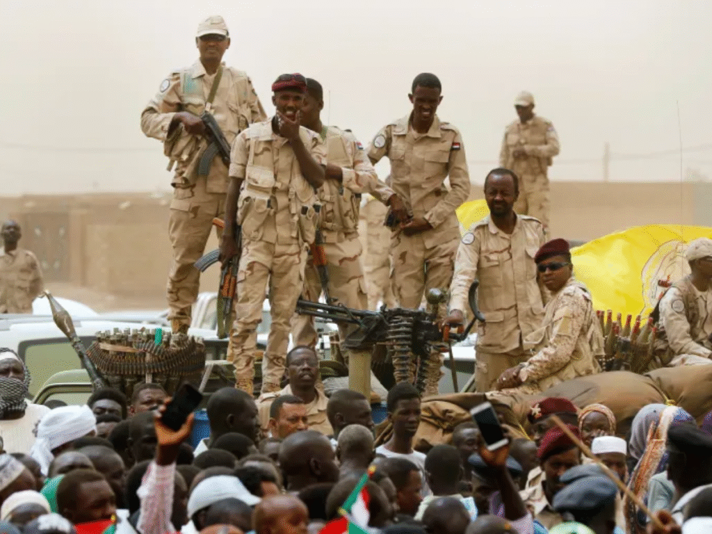 Members of the Rapid Support Forces stand on military vehicles amid a gathering of civilians in Sudan.