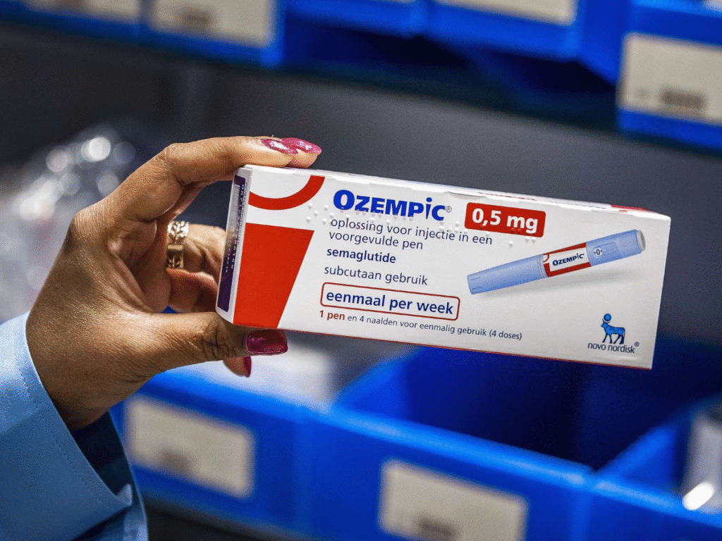 A person holding a box of Ozempic 0.5 mg injection pen in a storage area with blue bins in the background.