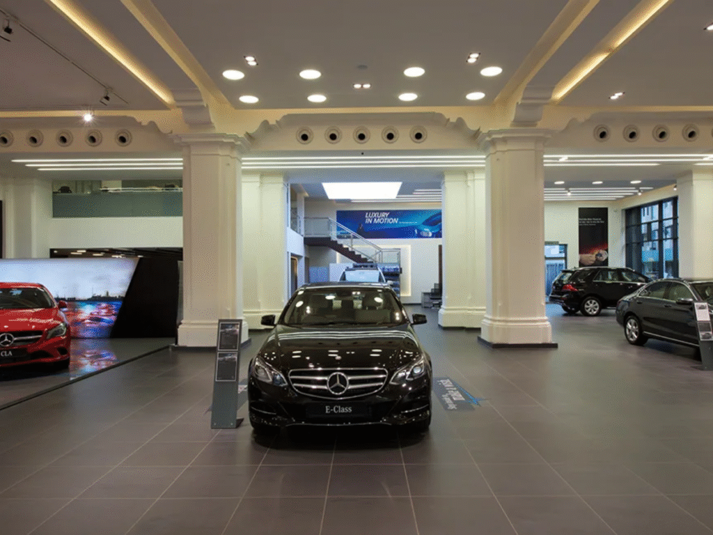 Interior view of a Mercedes-Benz showroom displaying multiple cars, including an E-Class model in the center.